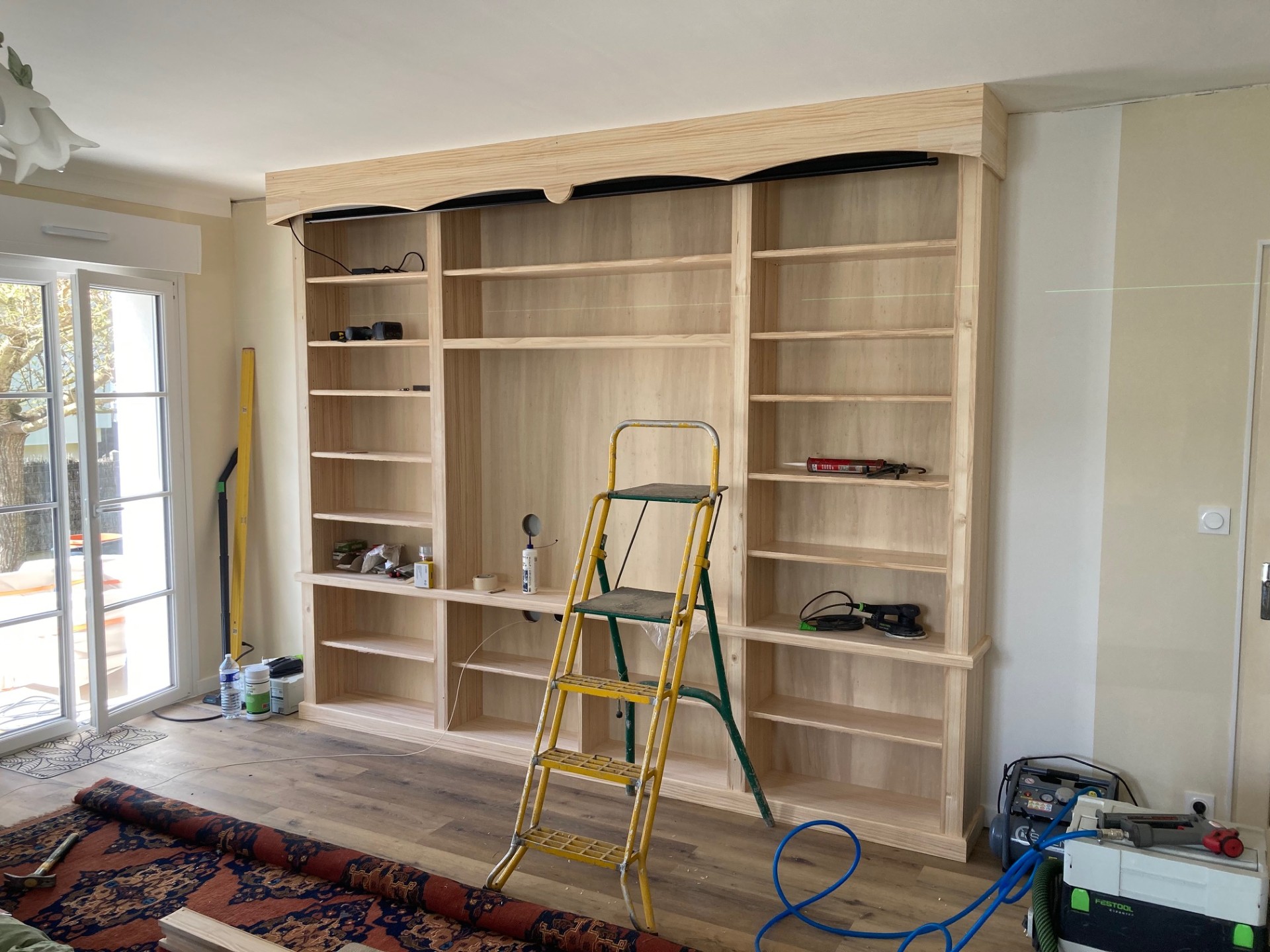 Bibliothèque et meuble d’agencement sur mesure en bois clair.