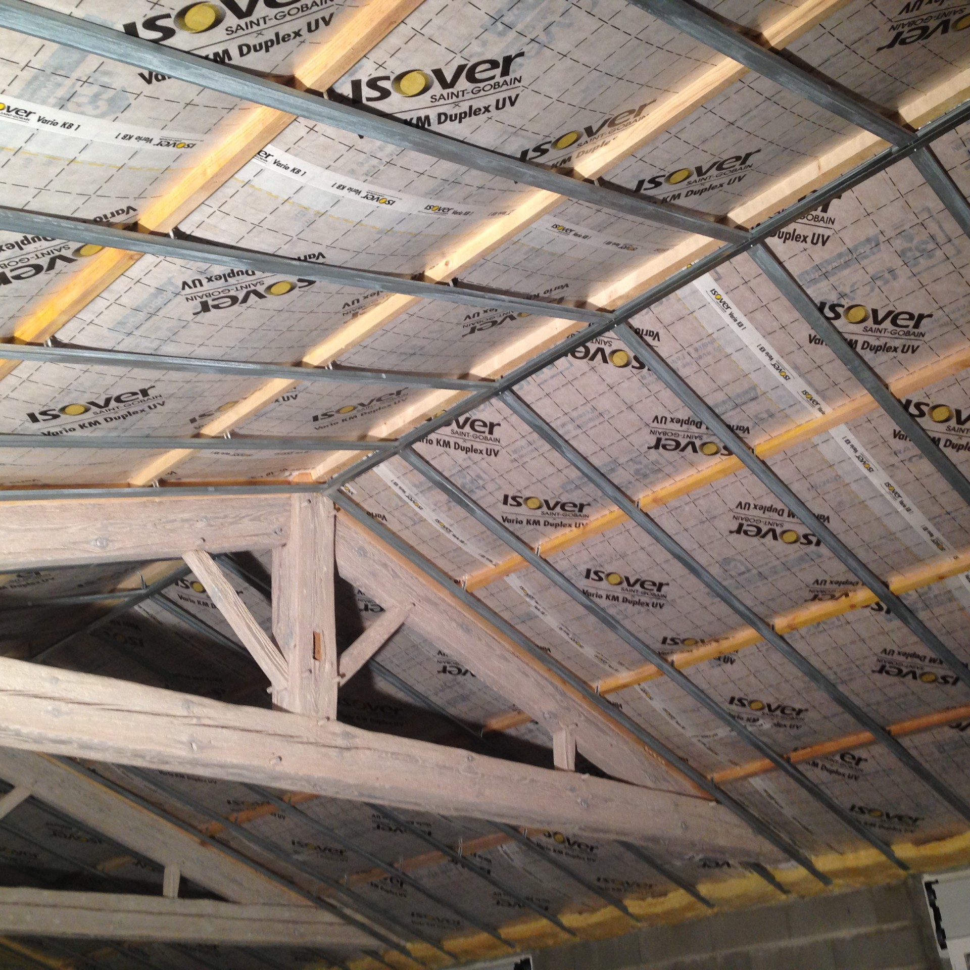 Isolation sous toiture avec structure métallique pour plafond.